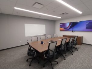 Meeting room with ACT ceiling and acoustical panels on two walls